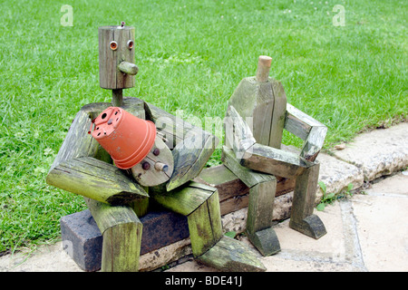 Holzfiguren sitzen in der Nähe von Garten Rasen England UK Stockfoto