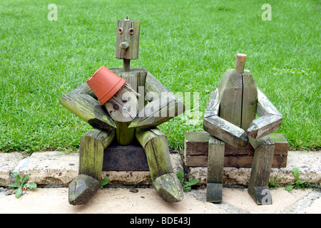 Holzfiguren sitzen in der Nähe von Garten Rasen England UK Stockfoto