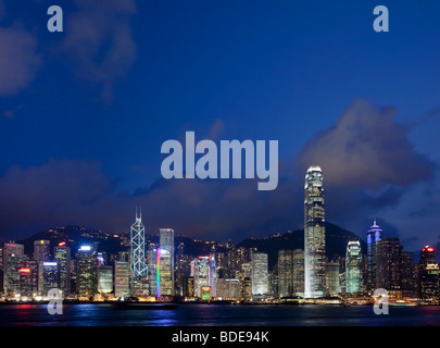 Blick über den Victoria Harbour von Hochhäusern bei Nacht in Hong Kong, China. Stockfoto