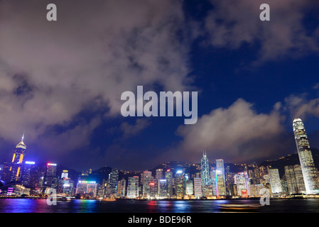 Blick über den Victoria Harbour von Hochhäusern bei Nacht in Hong Kong, China. Stockfoto