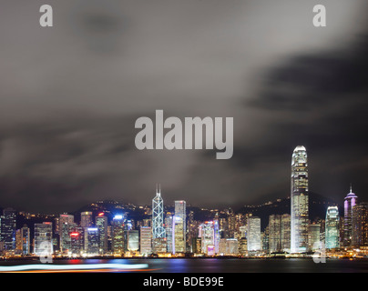 Blick über den Victoria Harbour von Hochhäusern bei Nacht in Hong Kong, China. Stockfoto