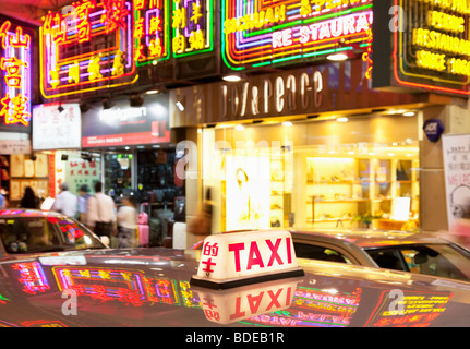 Leuchtreklamen und Taxi leicht in Tsim Sha Tsui, Kowloon, Hong Kong, China. Stockfoto