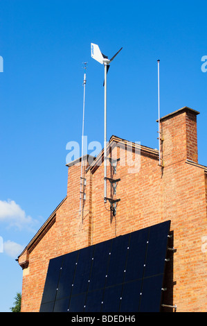 Windgenerator und Sonnenkollektoren angebracht, um die südliche Wand eines Wohnhauses in Leamington Spa, Warwickshire, UK. Stockfoto