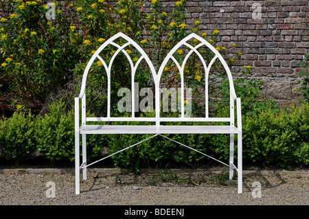 Schmiedeeisen Weißmetall Gartenbank formale vor Wand Stockfotografie