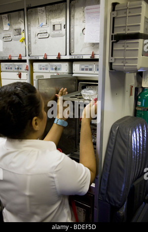 Mitglied der Kabinenbesatzung, die Zubereitung von Mahlzeiten in der Küche auf einem Virgin Atlantic Flugzeuge während des Fluges nach London aus Mumbai, Indien. Stockfoto