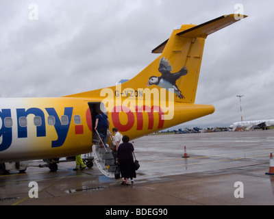 Passagiere, die ein Flugzeug Aurigny Airline A72 an einem regnerischen Tag am East Midlands Airport gebunden für Guernsey Stockfoto