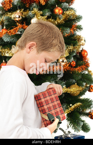 Kleiner Junge öffnen Weihnachtsgeschenk Weihnachtsbaum Stockfoto