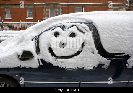 Smiley-Kunstwerk auf geparkten Auto nach starkem Schneefall, London, England, UK, Europa Stockfoto