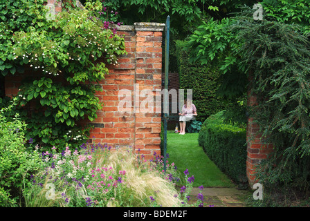 Eine Künstlerin, die an einem Aquarellgemälde in den Gärten von Cottesbrooke Hall, Northamptonshire, Großbritannien, arbeitet Stockfoto