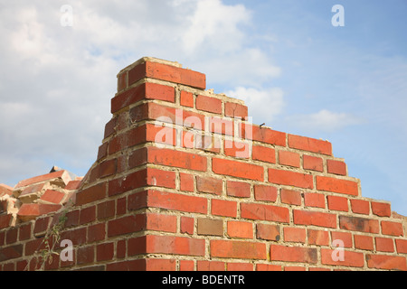 Abriss eines Hauses aus rotem Backstein mit einer Ecke von Ziegelbruch links. Stockfoto