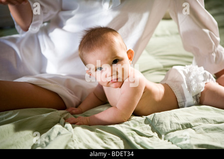 Nahaufnahme von 6 Monate altes Babymädchen und Mutter sitzt auf Bett Stockfoto