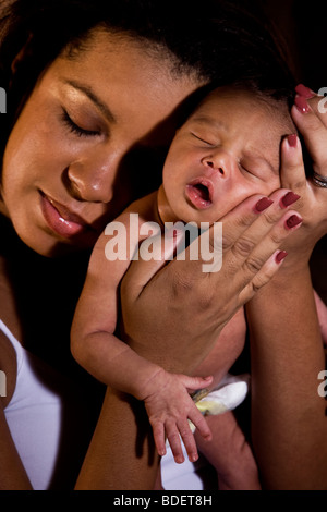 Afrikanisch-amerikanischen Mutter Holding neugeborenes Baby in Händen Stockfoto