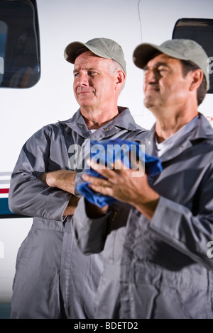 Zwei Flugzeug Mechaniker stehen neben kleinen Flugzeugen im hangar Stockfoto