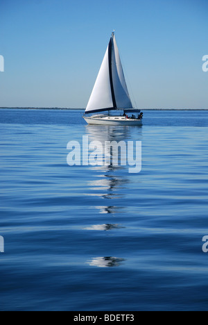 Ein Segelschiff Reflexion über das Wasser. Golf von Mexiko, Florida USA Stockfoto