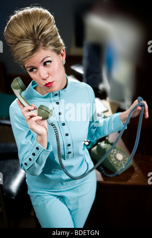 Vintage Porträt der jungen Sekretärin mit Bienenstock ans Telefon Stockfoto