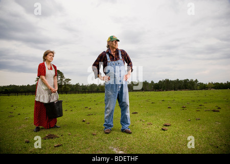 Älteres paar Arbeiten im Hof stehen auf der grünen Weide Stockfoto