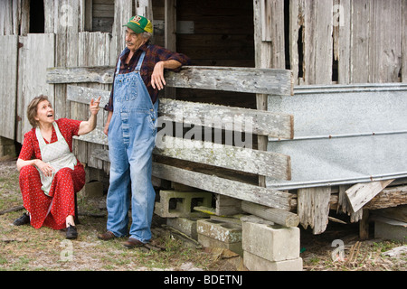 Älteres Paar auf Bauernhof in der Nähe von Scheune Stockfoto