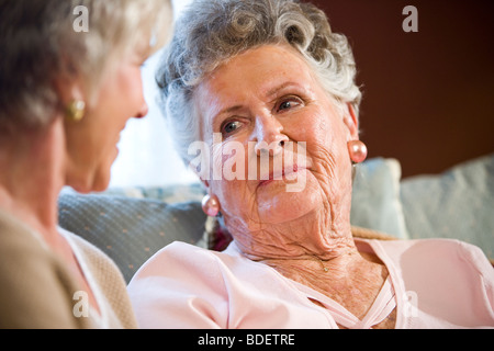Ältere Frau sitzt auf dem Sofa im Chat mit Freund Stockfoto