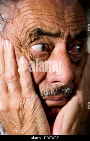 Nahaufnahme von besorgt senior Mann mit Händen auf Gesicht Stockfoto