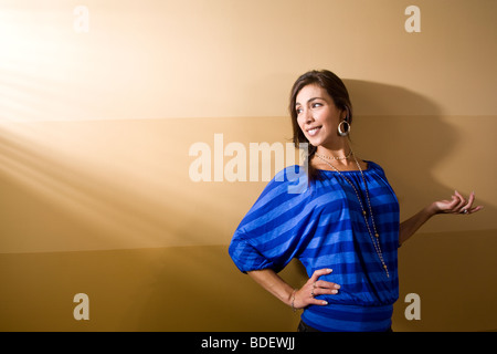 Hispanic Frau im blauen Hemd stehen gegen die Wand Stockfoto