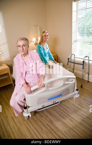 Alte Mutter und Tochter sitzen am Krankenhausbett in Pflegeheim Stockfoto