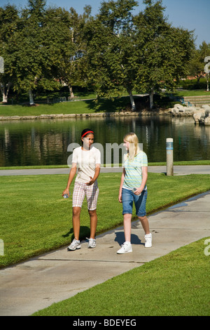 Zwei Rassen gemischt rassisch gemischten Mädchen hängen zusammen hängen. Hispanic und kaukasischen Junior high Mädchen zu Fuß Bürgersteig in den Park gehen. Herr © Myrleen Pearson Stockfoto