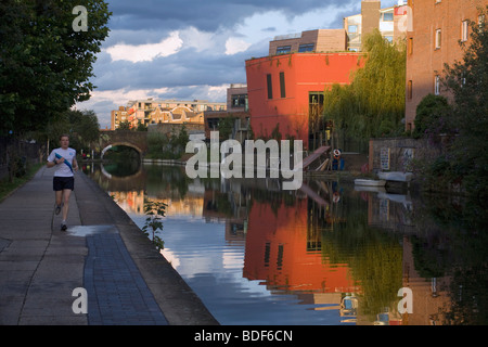 Ein Jogger, Regents Canal, einem roten Gebäude, eine interessante Himmel. London, UK. Stockfoto