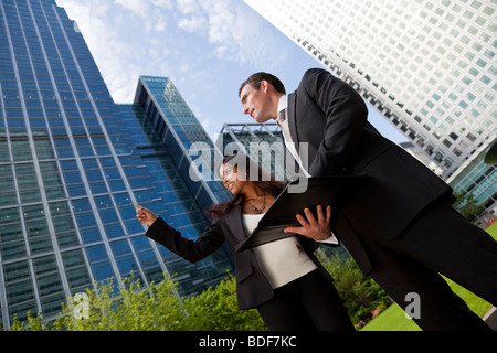 Eine lächelnde Geschäftsfrau und ihr männlicher Kollege Teilnahme an glücklich Geschäftstreffen außerhalb in einer modernen Stadt Stockfoto