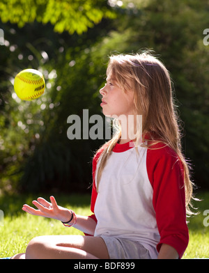 Mädchen wirft einen Ball in der Luft Stockfoto