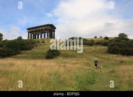Man Klettern in Richtung Penshaw Monument mit Hunden, North East England, Großbritannien Stockfoto