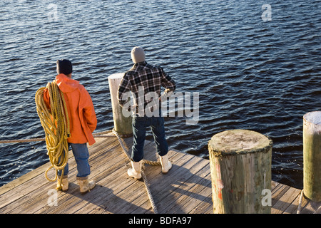 Rückansicht der junge Fischer stehen am Pier mit Seilen Stockfoto