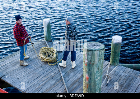 Rückansicht der junge Fischer stehen am Pier mit Seilen Stockfoto