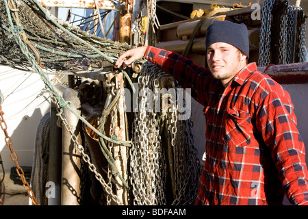 Junge Fischer im karierten Hemd gelehnt Fischerboot Stockfoto
