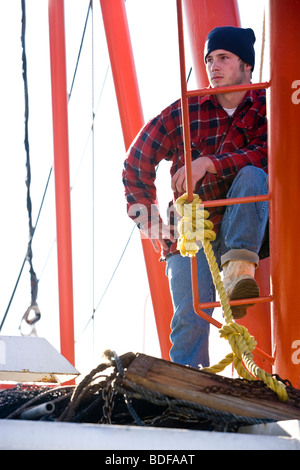 Junge Fischer im karierten Hemd mit Fischerboot Stockfoto