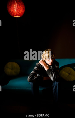 Gelangweilte Teenager auf Sofa drinnen sitzen Stockfoto