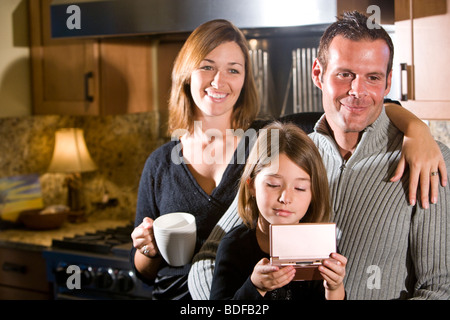 Liebevolle Familie mit drei sitzen in der Küche Stockfoto