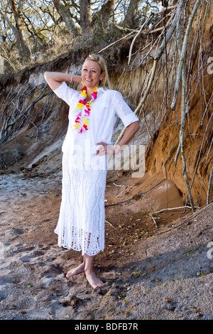 Frau mittleren Alters in Lei stehend auf sand Stockfoto