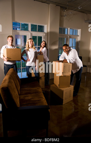 Multi-ethnischen Freunde und Paare mit Umzugskartons im Wohnzimmer Stockfoto