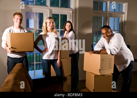 Multi-ethnischen Freunde und Paare mit Umzugskartons im Wohnzimmer Stockfoto