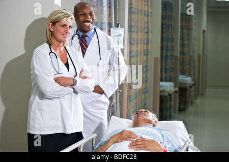 Multi-ethnischen Ärzte stehen bei Patienten im Krankenhaus Stockfoto