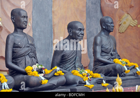 Statuen von Mönchen dekoriert mit Girlanden aus Blumen, Amulett-Markt in Bangkok, Thailand, Asien Stockfoto