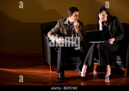 Geschäftsleute im Lounge-Bereich mit Laptop sitzen Stockfoto