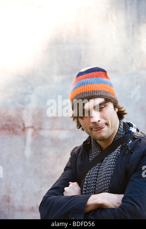 Junger Mann in warme Kleidung an an Hauswand gelehnt Stockfoto