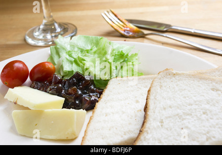 Vegan Cheese Plowman's Lunch auf einer Holzoberfläche mit Besteck Stockfoto