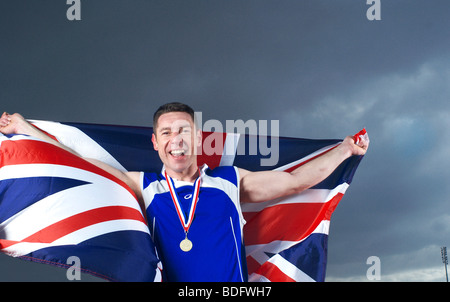 Athlet mit U.K Flagge und Medaille jubeln Stockfoto