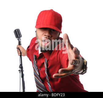 Afrikanische amerikanischer Mann gekleidet in roten Shirt und Cap singen und halten Vintage Mikrofon Stockfoto