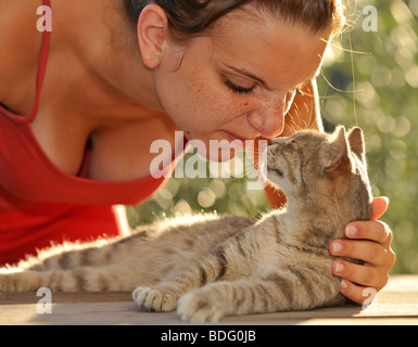 Tierliebe, Tabby Katze kuscheln mit Mädchen Stockfoto