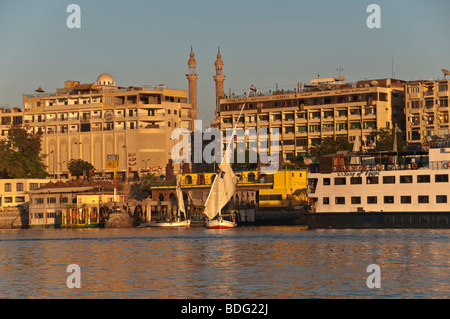 Feluken zwei traditionelle hölzerne Segelschiff auf Nil Fluss Assuan Ägypten mit Minaretten von islamischen Moschee in backgground Stockfoto