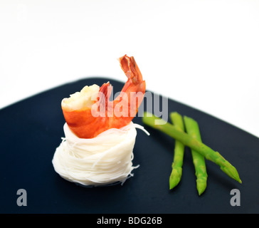 Scampi auf einem Bett aus Reisnudeln und Thai Spargel Stockfoto