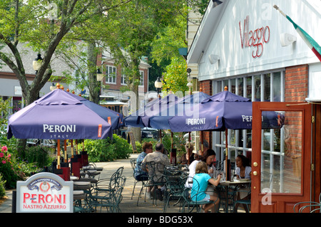 Die Innenstadt von Falmouth, Cape Cod Straßenszene mit Personen an Tischen mit Sonnenschirmen im Villaggio Restaurant im Sommer im Freien zu Speisen Stockfoto